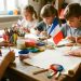 Atelier créatif du 14 juillet : des enfants bricolent autour d’une table avec du matériel de peinture, un drapeau tricolore et une cocarde, ainsi qu’un petit parchemin vierge.